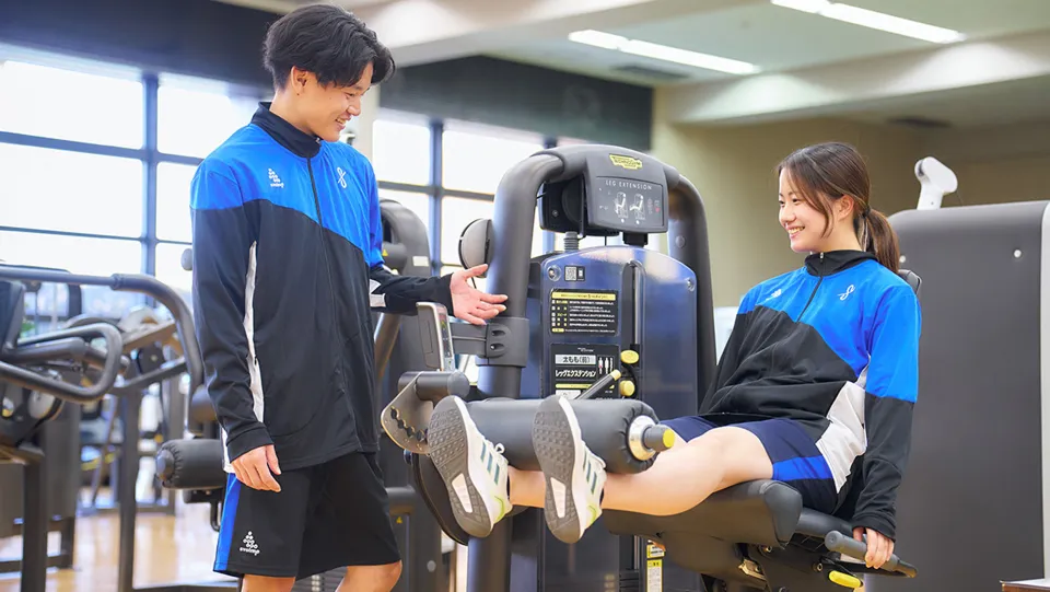 ウエイトマシンを使って筋トレをしている学生