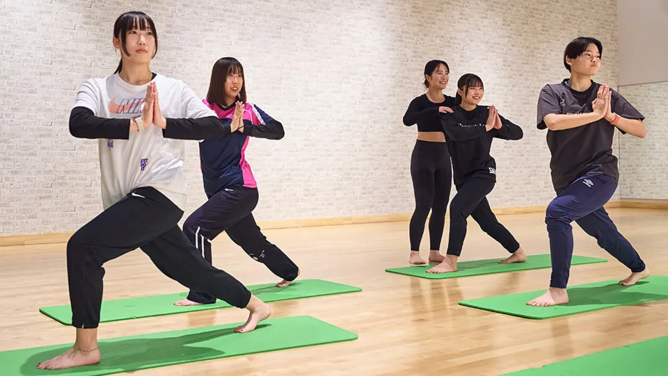 ウエイトマシンを使って筋トレをしている学生