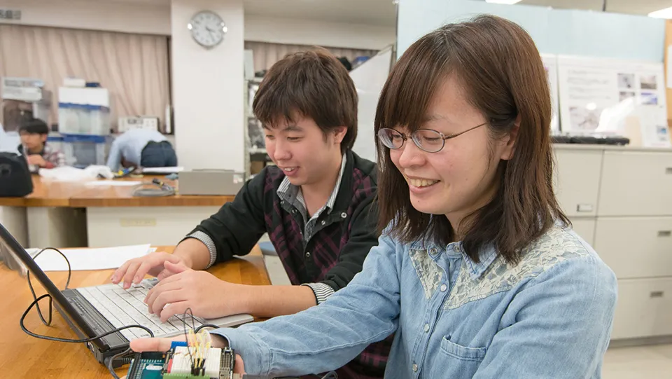 学生が講師から教わっている様子