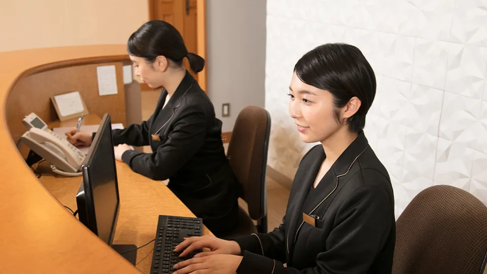 笑顔でパソコンの操作をしている学生