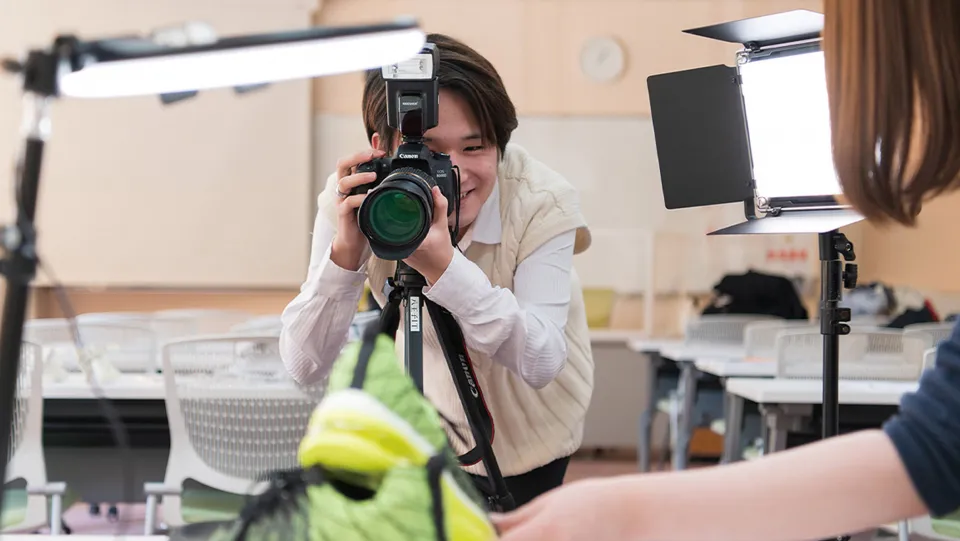 学生が笑顔でパソコン操作をしている様子