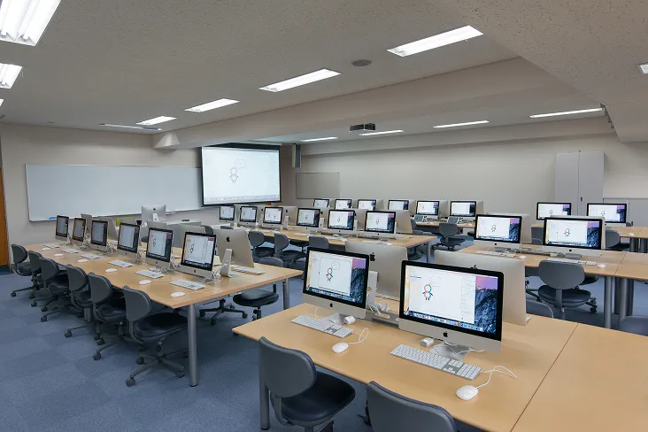 広い室内の全席に統一されたカラーのMacPCを完備したクールな室内