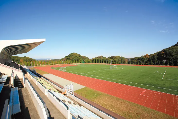 観客席から陸上トラックとサッカーコートを眺望する開放感ある風景