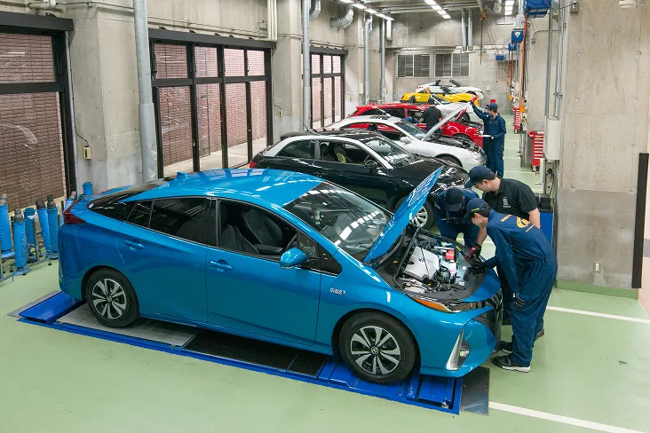 並んだ複数の車種のボンネットを開き整備実習を行っている様子