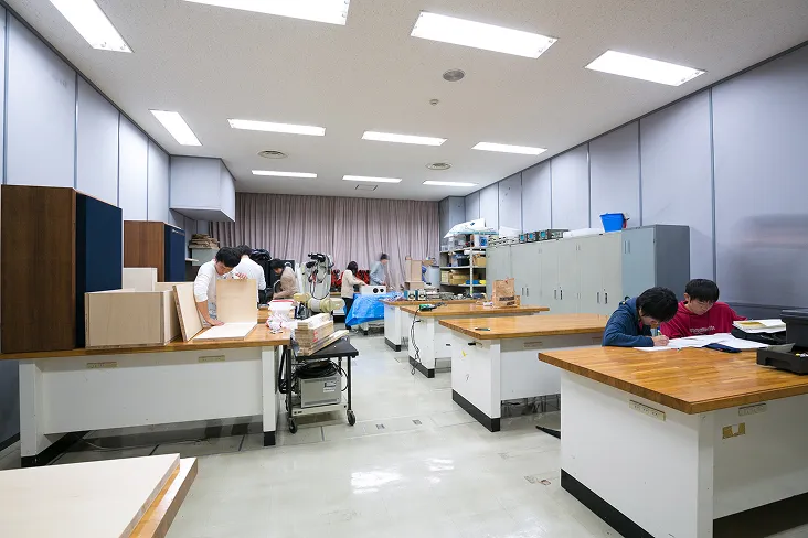 作業台に向かい組み立てや設計、分析などの作業を行う風景