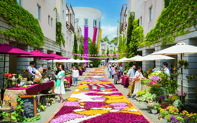 タイルが敷かれた花のような道の両脇に露店が並ぶ観光地のイメージ画像