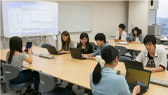 学生たちがスマートフォンやパソコンを使って学生する様子