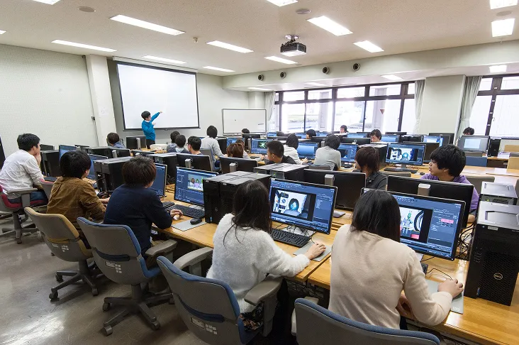 プロジェクターから投影された映像を見ながら説明を聞く生徒達