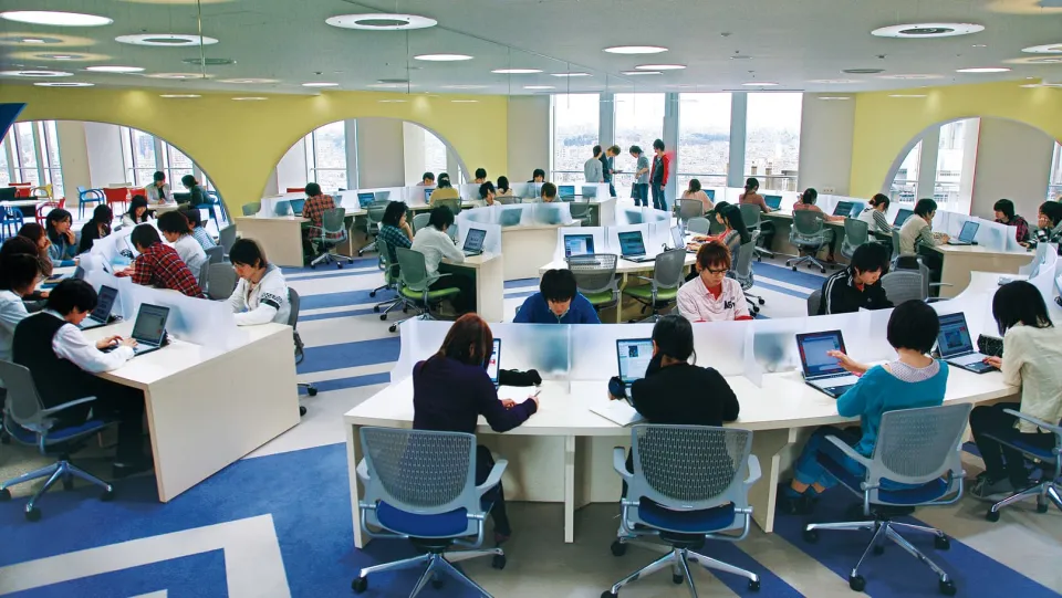 円形に配置されたデスクセットでノートPCを開き、自習に励んでいる生徒達の風景