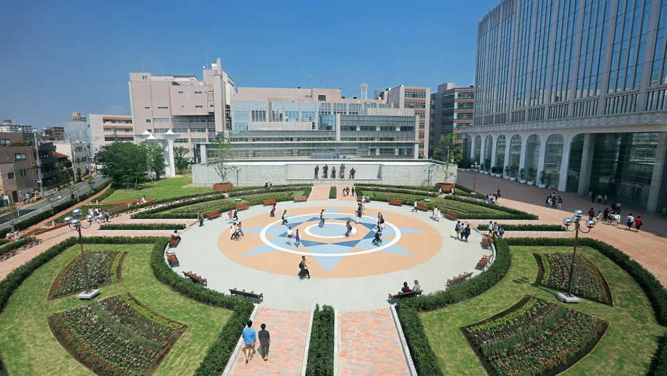 中心にある太陽のようなモチーフを囲むように花壇とタイルで円形にデザインされた庭園