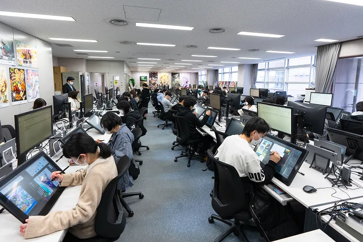 両手で抱えるサイズの大型液晶タブレットを一人一台使って実習に励む生徒達の風景