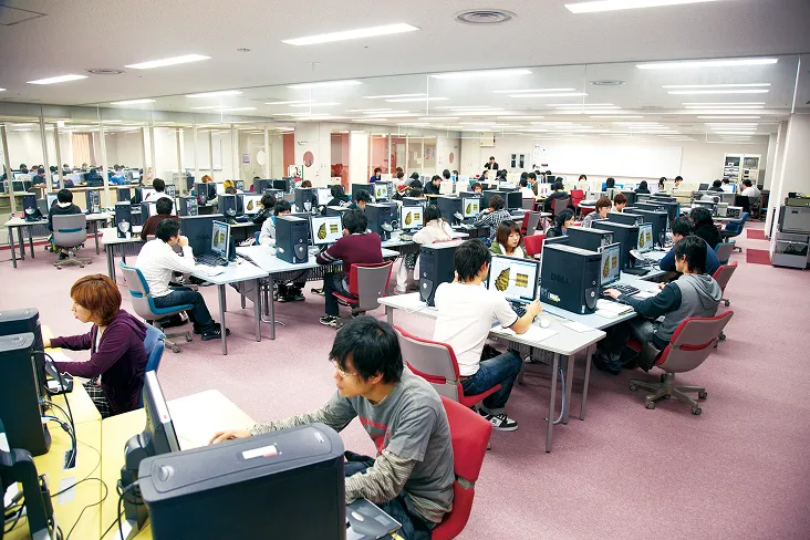 大きなデスクを斜めに組み合わせて集中できるスペースを確保した環境の中、制作に励む生徒達の様子