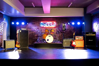 レンガ調の壁にネオンと照明が輝くライブステージ