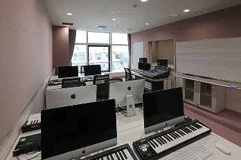 キーボードを完備した複数のPCに加え、ミキサーテーブルと音響機器も設置された室内