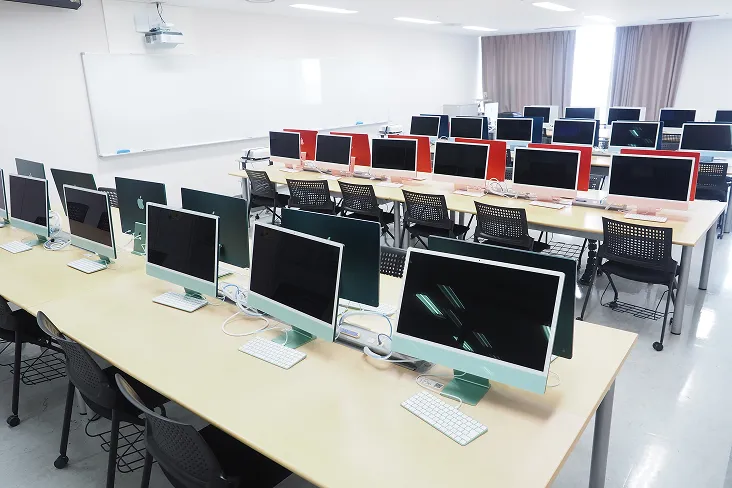 アップル社のカラフルなデスクトップPCを色ごとに列を作って配置した室内