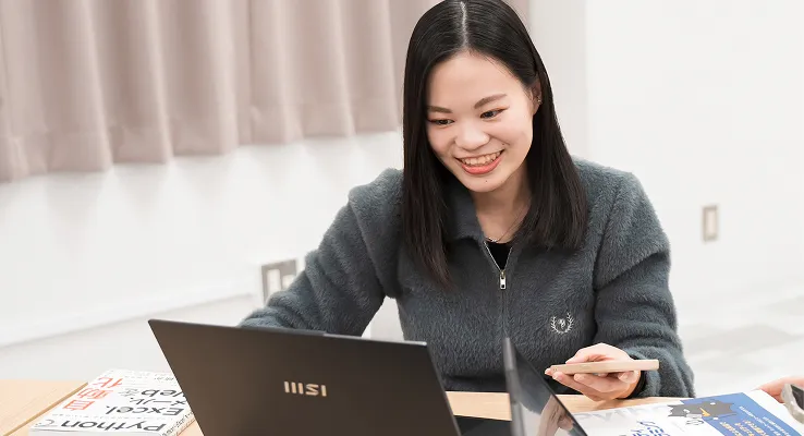 学生が教本とパソコンで学習する様子