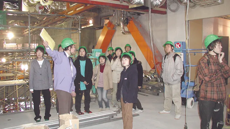 学生たちが工事中の建築現場を見学している様子
