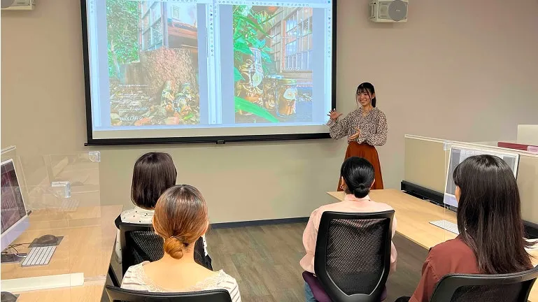 プロジェクターに映したポスターデザインを使って授業が行われている様子