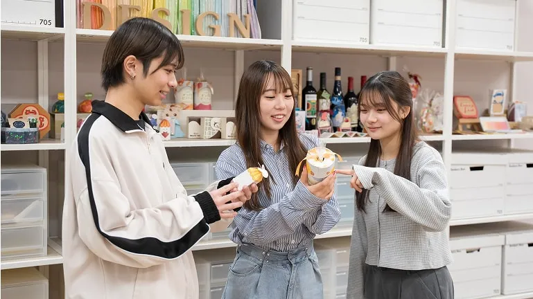 パッケージを手に持ちながら話し合っている学生たちの様子