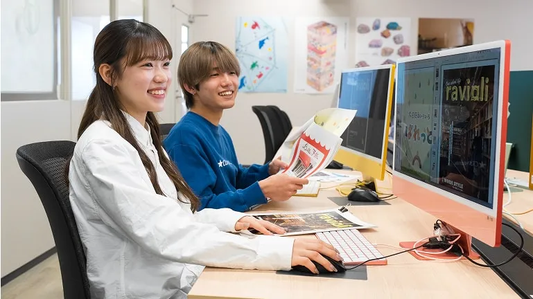 学生たちがパソコンで雑誌デザインを制作している様子