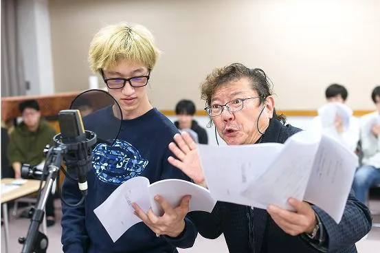 マイクの前で学生に指導する茶風林先生