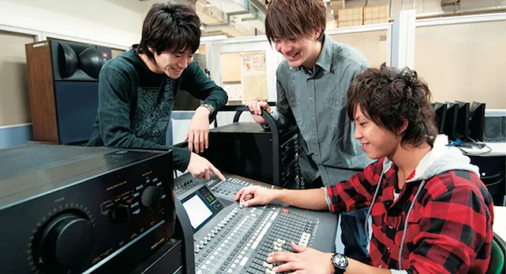 学生たちがスピーカーのシステム実験を行っている様子