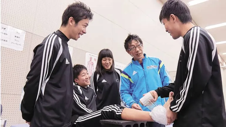 学生が怪我をした人に応急処置をしている様子