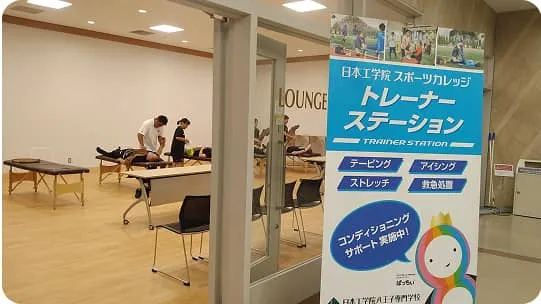 学生たちがベッドで横になっている人をサポートしている様子