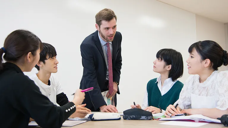 学生がメモを取りながら講師の話を聞く様子
