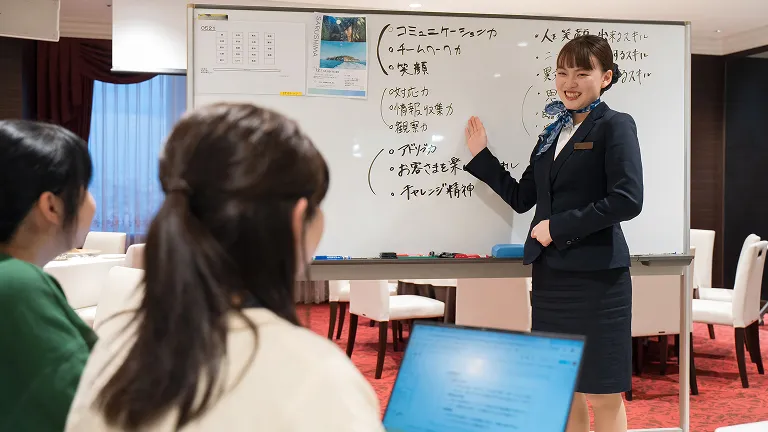 講師がホワイトボードを用いて授業を行い、学生が受講している様子