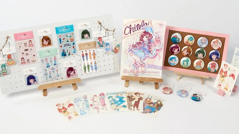 缶バッチやシールなどのイラストグッズが並んでいる様子