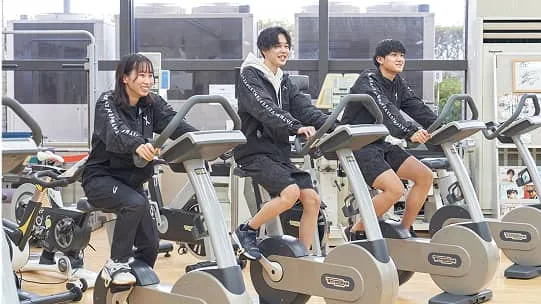 トレーニングマシンを使用している3人の学生の様子