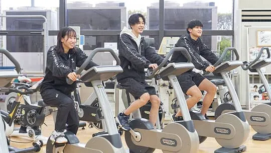 トレーニングマシンを使用している3人の学生の様子