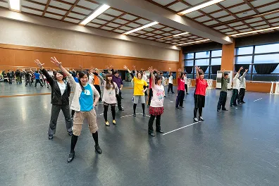 階段状の観客席を持つ総合グラウンドと8レーンあるプールの風景