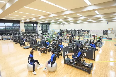 階段状の観客席を持つ総合グラウンドと8レーンあるプールの風景