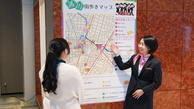 実習で街歩きマップを指し示しながら話す学生