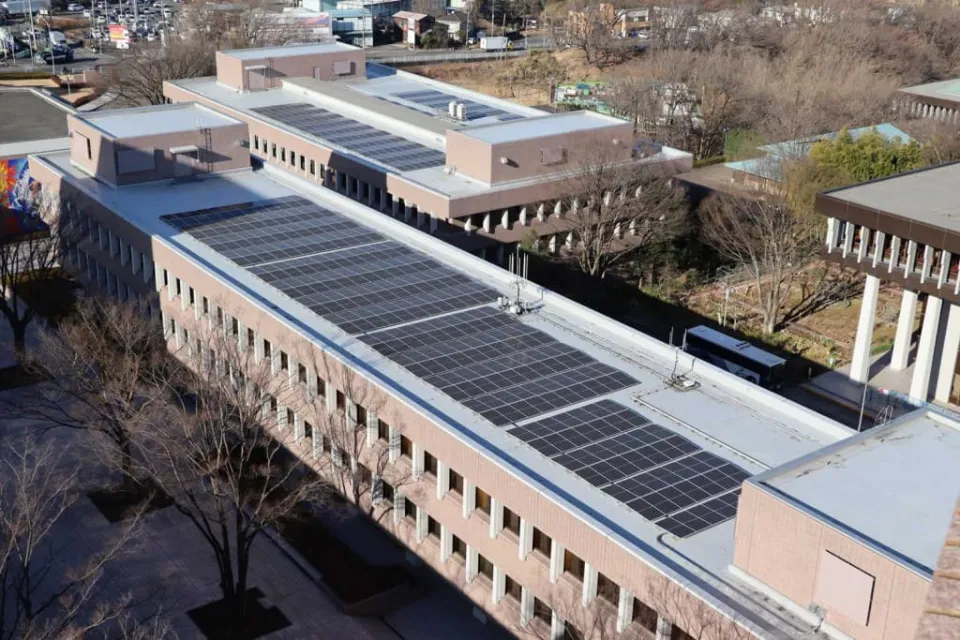 屋上にソーラーパネルが並んでいる高所から撮影した建物1