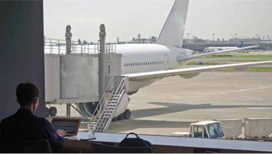 空港のラウンジから窓越しに見える駐機中の航空機