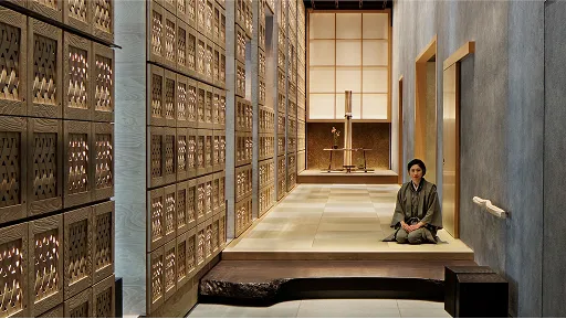 印象的な和風の壁と靴箱のあるエントランスと正座で迎えるスタッフ