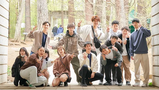 屋外で集合しポーズをとる学生たち