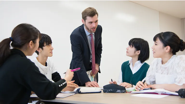学生がメモを取りながら講師の話を聞く様子