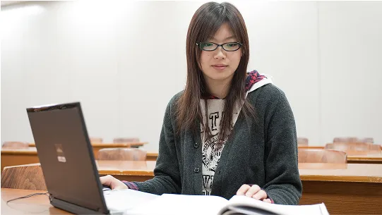 学生が教材を読みながらパソコンで学習する様子