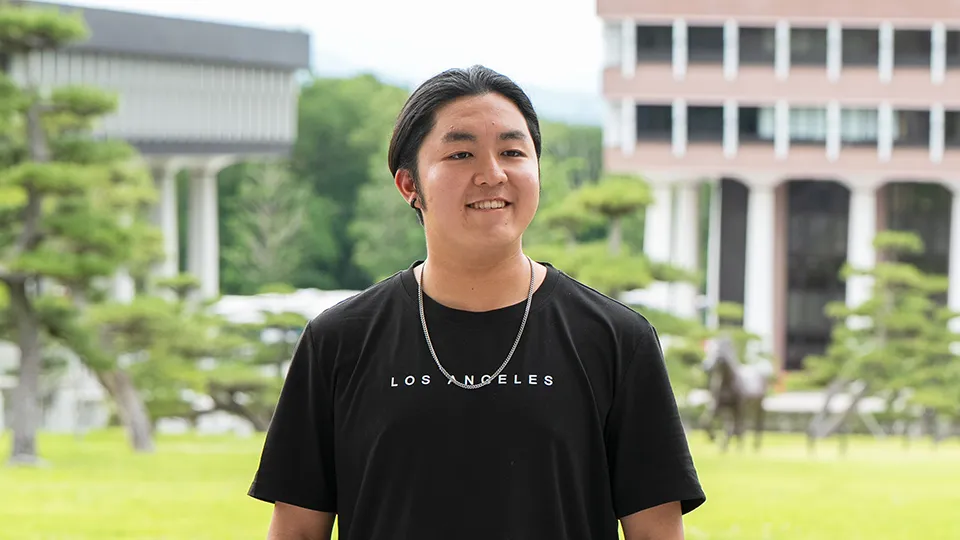 屋外で微笑んだ表情の髙橋 真弓先生