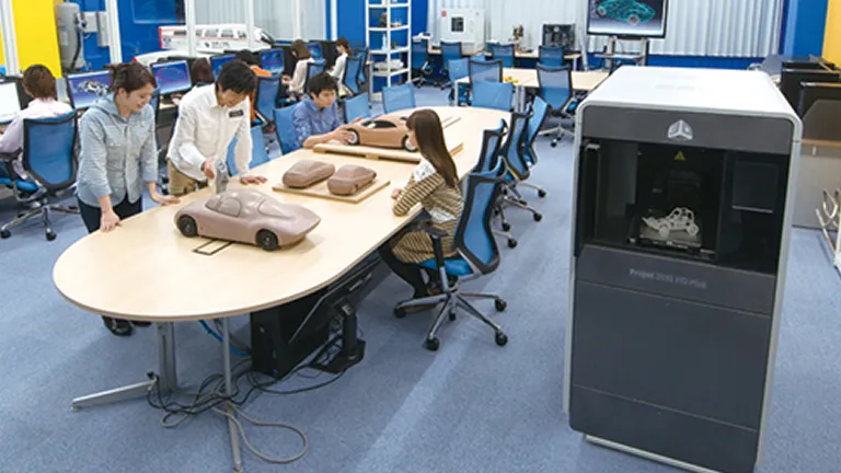 学生たちがテーブルの上に並んでいる車の模型を見ている様子