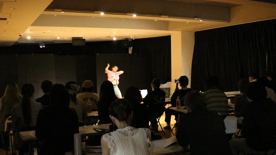 学生が講師たちの前でダイナミックにダンスパフォーマンスをする様子