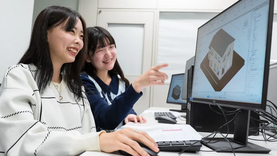 女性が木材をカットしているところを後ろから学生たちが見ている様子