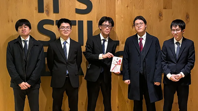 チーム「時間厳守」のメンバーが記念撮影をしている様子