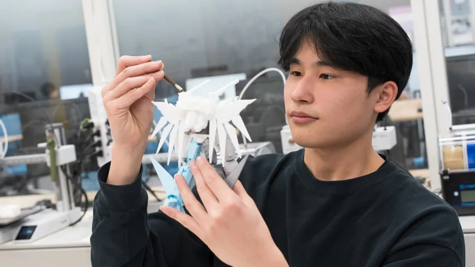 固定された出力デバイスのアームをペンを持つようにして実際に使用している様子