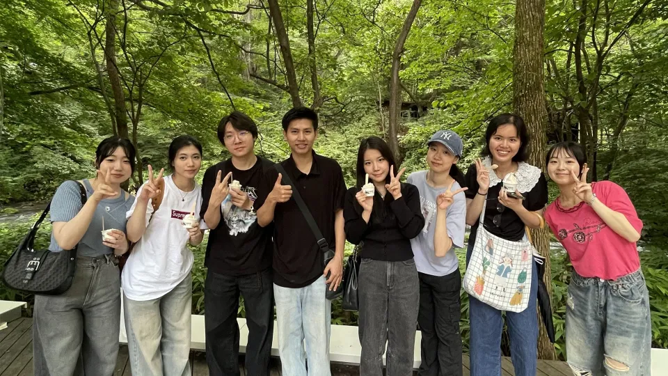 豊かな森をバックに記念撮影をする学生たち