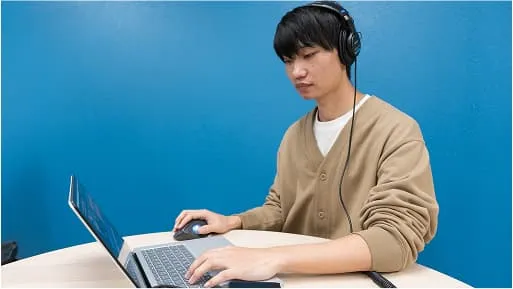 学生がヘッドフォンをつけてパソコンで作業をしている様子